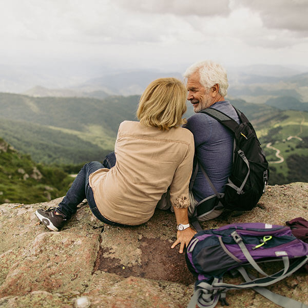 elderly couple hanging out on edge of cliff