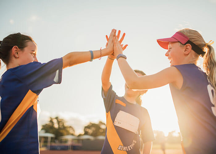 young girls high fiving during sports game