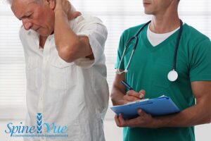 A healthcare professional assessing a patient's neck and spine for pain treatment in Dallas, TX.

