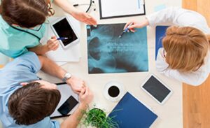 Medical team reviewing spinal X-rays and discussing Spine Surgery treatment options in Dallas, TX.