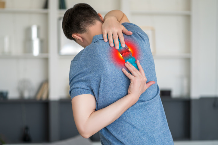Person experiencing neck pain from a herniated cervical disc in Houston & Texas
