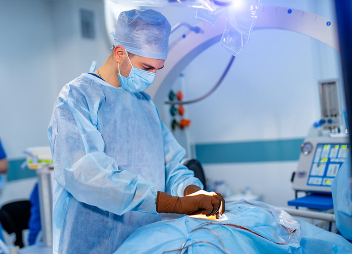 Surgeon performing a laminectomy procedure in an operating room in Houston & Texas