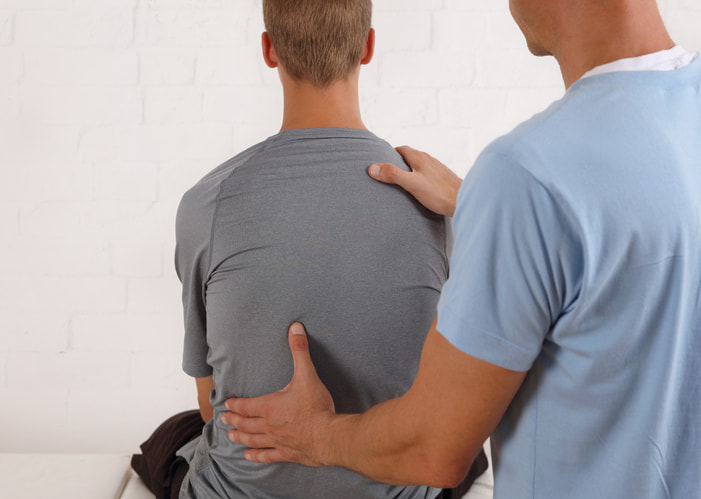 Healthcare provider evaluating a patient with spondylolysis in Dallas & Texas
